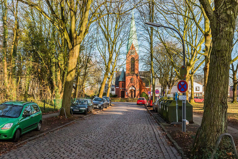 Edificio eclesiástico de ladrillo rojo en un parque del distrito de Hamburgo-Eidelstedt - Pisos amueblados de City-Wohnen