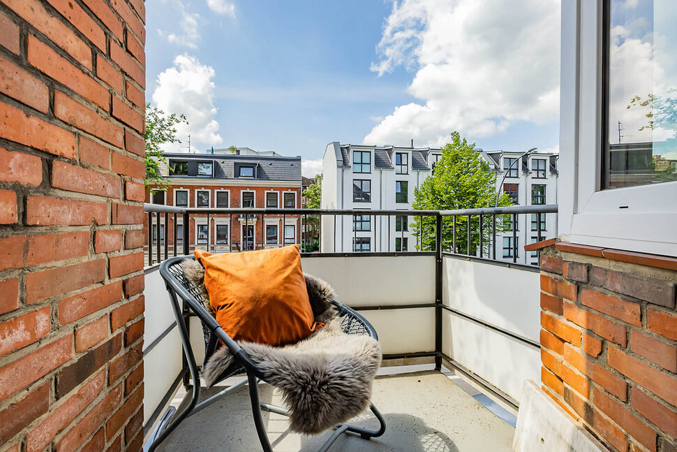 Small, sheltered balcony and sitting area with cozy lambskin in Hamburg-Stellingen district - Furnished apartments by City-Wohnen